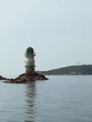 a lighthouse on an island in the water at Corse du Sud Villa les pieds dans l'eau ! in Zonza