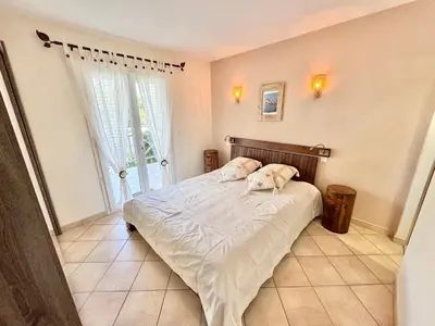 a bedroom with a bed and a large window at Villa à Porto-Vecchio - Résidence privé in Porto-Vecchio