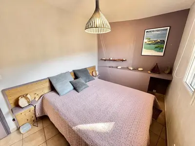 a bedroom with a bed with blue pillows at Villa à Porto-Vecchio - Résidence privé in Porto-Vecchio