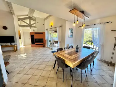 a dining room with a wooden table and chairs at Villa à Porto-Vecchio - Résidence privé in Porto-Vecchio
