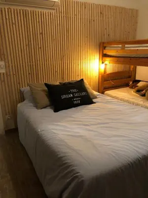 a bed with a black pillow on top of it at Beautiful villa, pool, sea, 5 bedrooms in Zonza