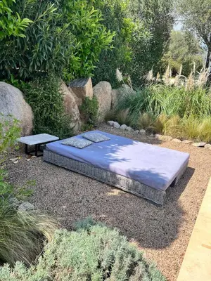 a mattress and a bench in a garden at Beautiful villa, pool, sea, 5 bedrooms in Zonza
