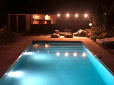 a swimming pool in a backyard at night at Beautiful villa, pool, sea, 5 bedrooms in Zonza