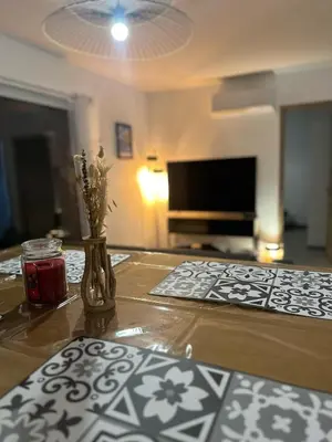 a table with a vase with flowers in a living room at I Sognu - Charmant Appartement Neuf Proche du Port in Porto-Vecchio