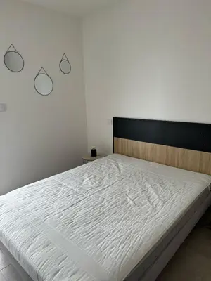 a bedroom with a large bed with white sheets at I Sognu - Charmant Appartement Neuf Proche du Port in Porto-Vecchio