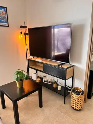 a living room with a flat screen tv on a stand at I Sognu - Charmant Appartement Neuf Proche du Port in Porto-Vecchio