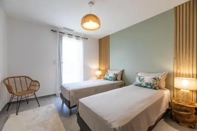 a bedroom with two beds and a chair and a window at VILLA VITRICCIA - VILLA DE REVE, PISCINE et PLAGE à 7MN A PIED ! in Zonza