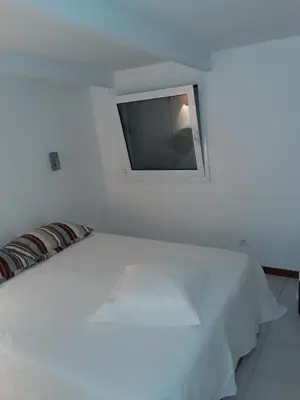 a white bed with a flat screen tv on the wall at Camping Residence Chalet La Pomposa Terrazzoni in Bonifacio