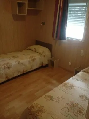 a small bedroom with two beds and a window at Camping Residence Chalet La Pomposa Terrazzoni in Bonifacio