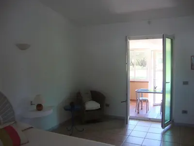 a bedroom with a bed and a table and a chair at Camping Residence Chalet La Pomposa Terrazzoni in Bonifacio