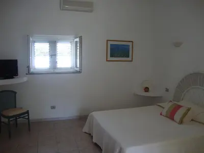 a white bedroom with a bed and a window at Camping Residence Chalet La Pomposa Terrazzoni in Bonifacio