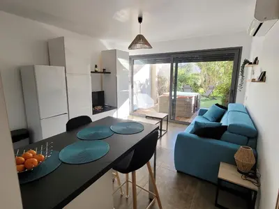 a kitchen and living room with a blue couch at Studio Port de Porto-Vecchio in Porto-Vecchio