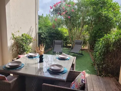 a table with plates and glasses on a patio at Studio Port de Porto-Vecchio in Porto-Vecchio