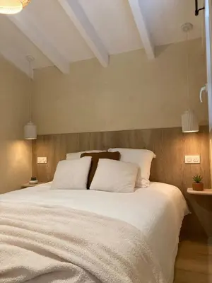 a bedroom with a large white bed with two pillows at La mini villa Ondella à Porticcio in Grosseto-Prugna