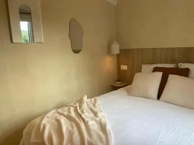 a bedroom with a gold bed and a table at La mini villa Ondella à Porticcio in Grosseto-Prugna
