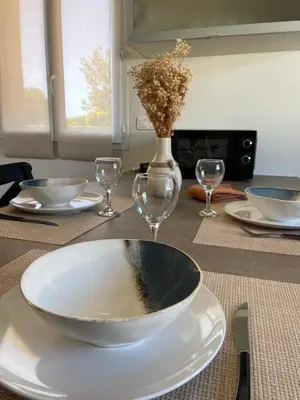 a bowl on a plate on a table with wine glasses at Les oliviers in Aléria