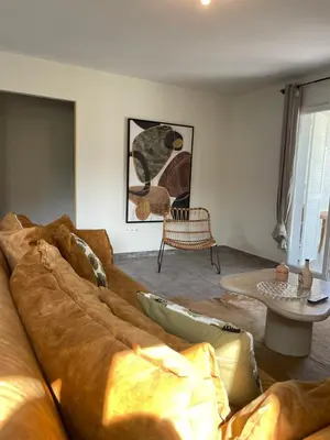 a living room with a brown couch and a table at Les oliviers in Aléria