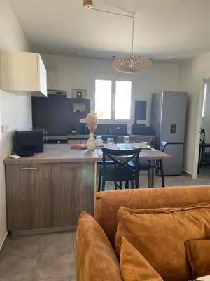 a kitchen and dining room with a couch and a table at Les oliviers in Aléria