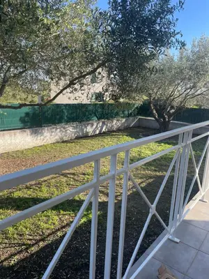 a white fence in front of a park at Les oliviers in Aléria