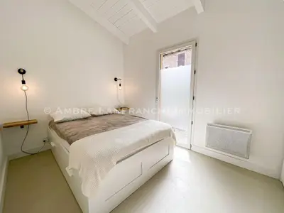 a white bedroom with a bed and a window at Maison en pierre - 6 personnes - piscine in Porto-Vecchio