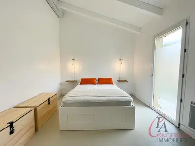 a white bedroom with a bed and a window at Maison en pierre - 6 personnes - piscine in Porto-Vecchio