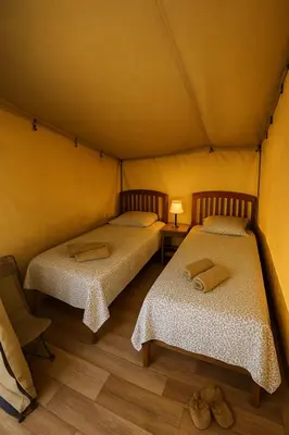 a large tent with a wooden deck in a field at Camping Mercone in Corte