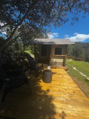 a wooden deck with two chairs and a gazebo at Camping Mercone in Corte