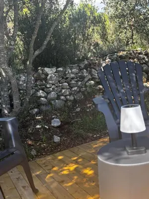 a blue chair and a lamp on a wooden deck at Camping Mercone in Corte