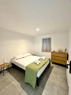 a bedroom with a bed and a dresser in it at Maison avec jardin et proche mer in Propriano