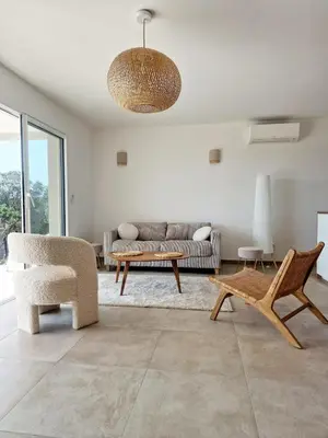 a living room with a couch and a table and chairs at Villa neuve piscine privée chauffée Bonifacio in Bonifacio