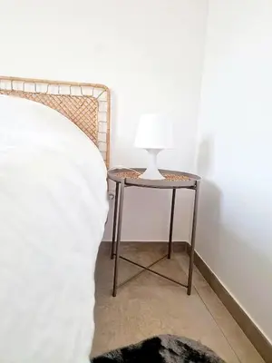 a table with a lamp on it next to a bed at Villa neuve piscine privée chauffée Bonifacio in Bonifacio
