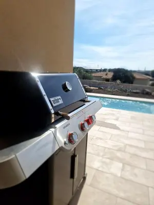a kitchen with a stove with a pool in the background at Villa neuve piscine privée chauffée Bonifacio in Bonifacio