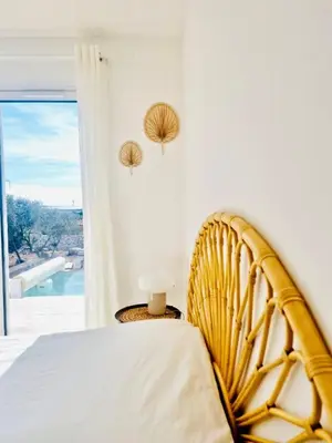 a bedroom with a bed and a large window at Villa neuve piscine privée chauffée Bonifacio in Bonifacio