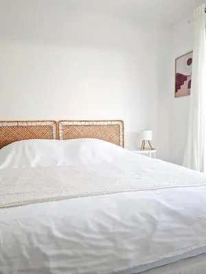 a bedroom with a white bed with a white bedspread at Villa neuve piscine privée chauffée Bonifacio in Bonifacio