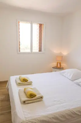 a white bedroom with a bed with towels on it at Domaine de Campu in Vallecalle