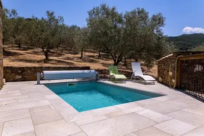 a swimming pool with a bench and two chairs at Domaine de Campu in Vallecalle