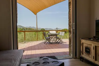 a room with a door open to a patio with a table at Domaine de Campu in Vallecalle