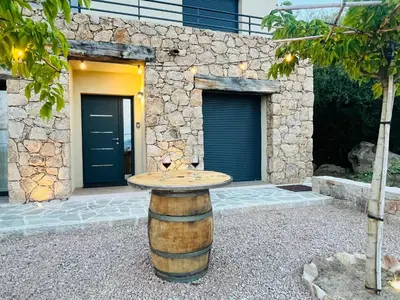 a table on a barrel in front of a building at Villa ALTEA , au cœur du Maquis , 4 chambres , Figari in Figari