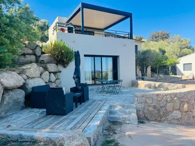 a house with a statue on a wooden deck at Villa ALTEA , au cœur du Maquis , 4 chambres , Figari in Figari