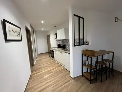 a kitchen with white cabinets and a table and chairs at Villa ALTEA , au cœur du Maquis , 4 chambres , Figari in Figari