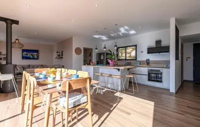 a kitchen and living room with a table and chairs at Villa ALTEA , au cœur du Maquis , 4 chambres , Figari in Figari