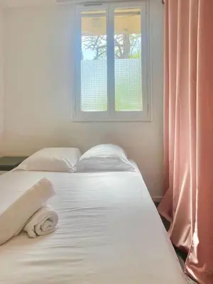 a white bed in a room with a window at Ajaccio centre ville joli T2 Grandval in Ajaccio