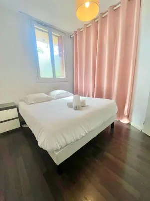 a bed in a room with a pink curtain at Ajaccio centre ville joli T2 Grandval in Ajaccio