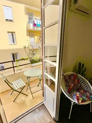 a room with a balcony with a table and a chair at Ajaccio centre ville joli T2 Grandval in Ajaccio