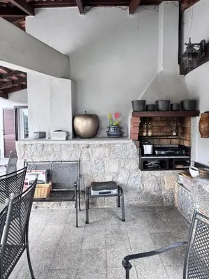 a patio with chairs and a stone fireplace at Nouveau ! Villa avec piscine - Sainte-Marie-Siché in Santa-Maria-Siché