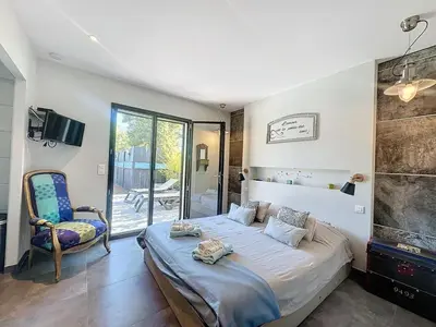 a bedroom with a bed and a chair in it at Villa Macchia di Cervi in San-Gavino-di-Carbini
