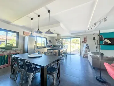 a kitchen and living room with a table and chairs at Villa Macchia di Cervi in San-Gavino-di-Carbini