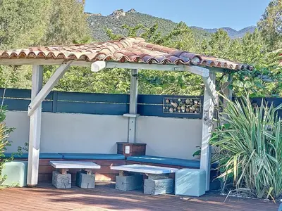 a bench under a gazebo with a roof at Villa Macchia di Cervi in San-Gavino-di-Carbini