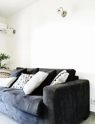 a black couch in a living room with pillows at Le Diodon De Sagone in Sagone