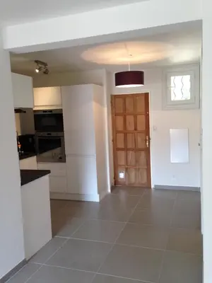 a kitchen with white cabinets and a door at Le Diodon De Sagone in Sagone